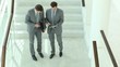 Business partners walking downstairs and meeting Business partners walking downstairs and meeting
