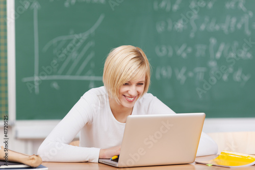 Photo: lachende studentin arbeitet am laptop lachende studentin arbeitet am laptop