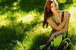 brunette sitting on green grass