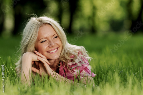Photo: blonde lying on green grass blonde lying on green grass
