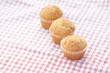 three muffins on plaid fabric