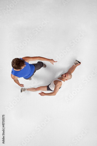 Photo: Overhead view of muscular man training with personal trainer Overhead view of muscular man training with personal trainer