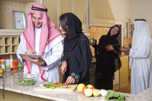 Photo: arabian couples gathering cooking & drinking coffee in kitchen arabian couples gathering cooking & drinking coffee in kitchen
