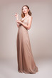 Beautiful young woman wearing a sexy beige evening dress