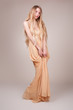 Beautiful young woman wearing a sexy beige evening dress