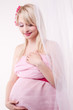 beautiful young pregnant woman wrapped into pink fabric
