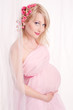 beautiful young pregnant woman wrapped into pink fabric