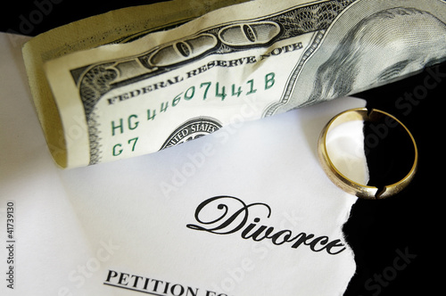 Photo: torn divorce decree and cash, with broken wedding ring torn divorce decree and cash, with broken wedding ring