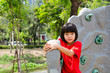 child climbing on a wall in park child climbing on a wall in park