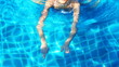 Pretty blond sexy woman is swimming in the pool