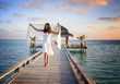 Photo: Sexy happy woman in white clothes standing on a jetty (Maldives) Sexy happy woman in white clothes standing on a jetty (Maldives)