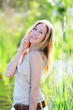 Beautiful blond woman standing in meadow with modern look Beautiful blond woman standing in meadow with modern look