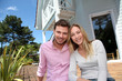 Portrait of smiling couple standing in front of house