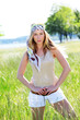Beautiful blond woman standing in meadow with modern look Beautiful blond woman standing in meadow with modern look