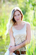 Beautiful blond woman standing in meadow with modern look Beautiful blond woman standing in meadow with modern look