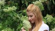 Frau riecht an Holunderblüten Frau riecht an Holunderblüten