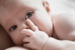 infant lies in her mother's breast and closes her palm face