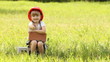 Little girl in the construction helmet sits on cinder block