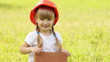 Girl with red brick building. She in construction helmet
