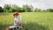 3s girl on the field with a picture house. Looking at camera