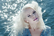 Portrait of beautiful young woman against water