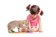 Cute kid drawing with pencils. Kitten next to girl.