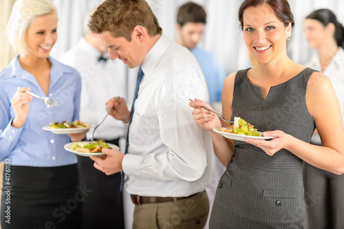 Photo: Smiling business woman during company lunch buffet Smiling business woman during company lunch buffet