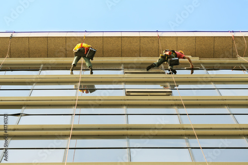 Photo: Washers wash the glass facade of modern skyscraper Washers wash the glass facade of modern skyscraper