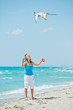 Woman on beach playing with a colorful kite