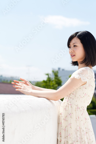 Photo: Beautiful young woman outdoors over blue sky Beautiful young woman outdoors over blue sky