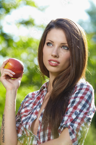 Photo: Beautiful woman in the garden with apples Beautiful woman in the garden with apples