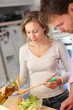 Couple enjoying preparing dinner in kitchen Couple enjoying preparing dinner in kitchen