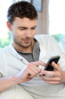 Young man using mobile phone to send short message