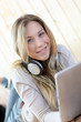 Young modern girl listening to music with electronic tablet