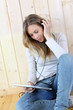 Young modern girl listening to music with electronic tablet