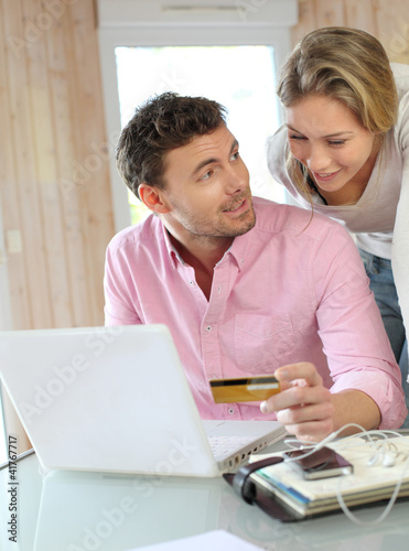 Photo: Couple using credit card to shop online Couple using credit card to shop online