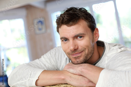 Photo: Portrait of young smiling man relaxing in sofa Portrait of young smiling man relaxing in sofa