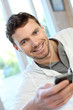 Young man using mobile phone with handsfree headset Young man using mobile phone with handsfree headset