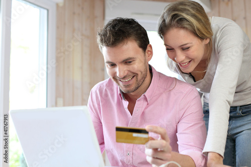 Photo: Couple using credit card to shop online Couple using credit card to shop online