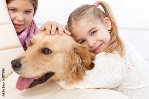Photo: Little girl hugging pet dog smiling Little girl hugging pet dog smiling
