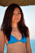 Asian girl with bikini under straw umbrellas2