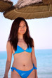 Asian girl with bikini under straw umbrellas1