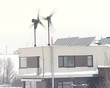 windmills and solar panels on roof of building in winter windmills and solar panels on roof of building in winter