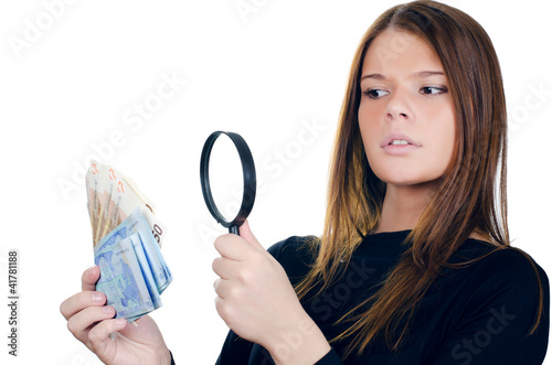 Photo: Woman with magnifying glass and euro cash money Woman with magnifying glass and euro cash money