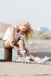 young smiling woman getting ready for rollerblading / roller ska