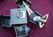 Young business woman with laptop resting on chair