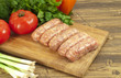 Raw sausages and fresh vegetables closeup.