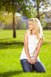 Beautiful girl sitting on the grass in the park