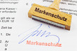 Holzstempel auf Dokument: Markenschutz