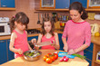 Family cooking at home. Happy mother with kids cook salad